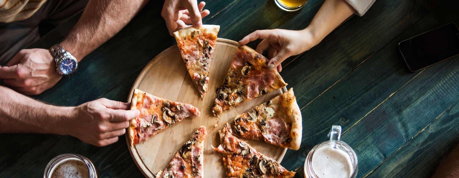 a group of people eating pizza